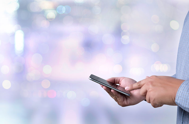 Close up of customer pressing screen on smart phone with purple bokeh background