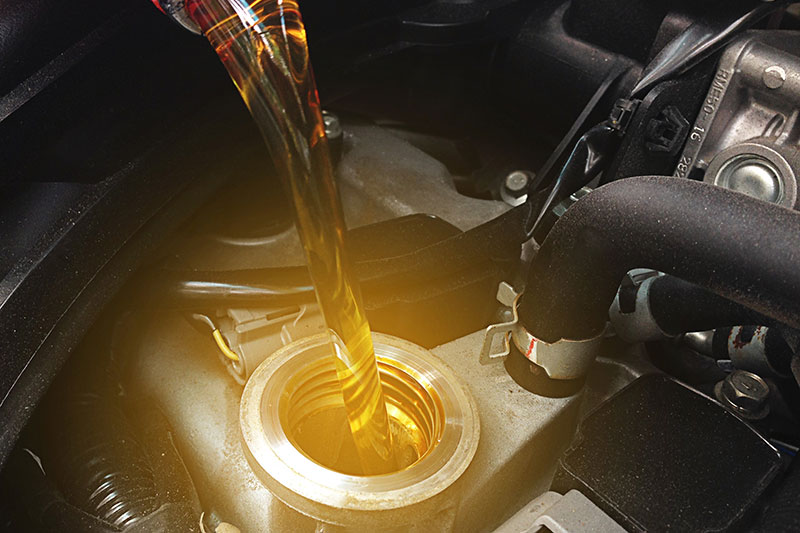 close up of oil being poured into engine
