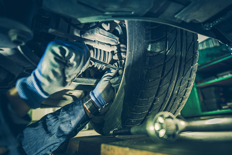 mechanic working on car suspension