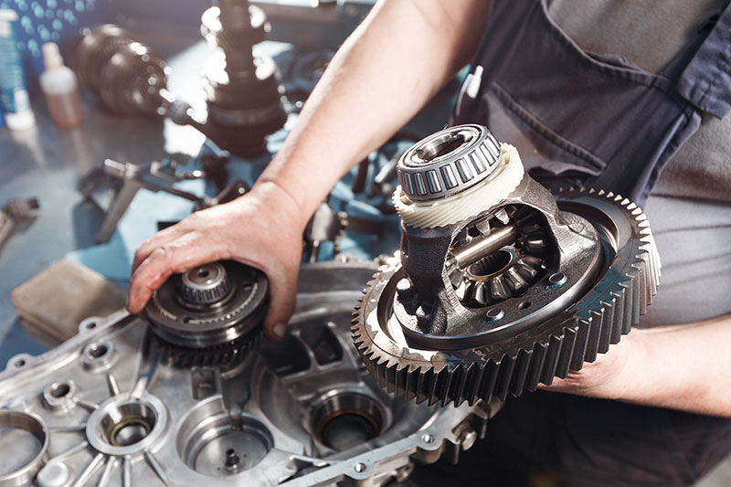 mechanic disassembling car transmission