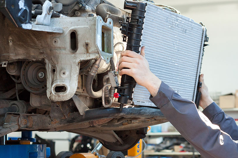 close up of mechanic replacing radiator